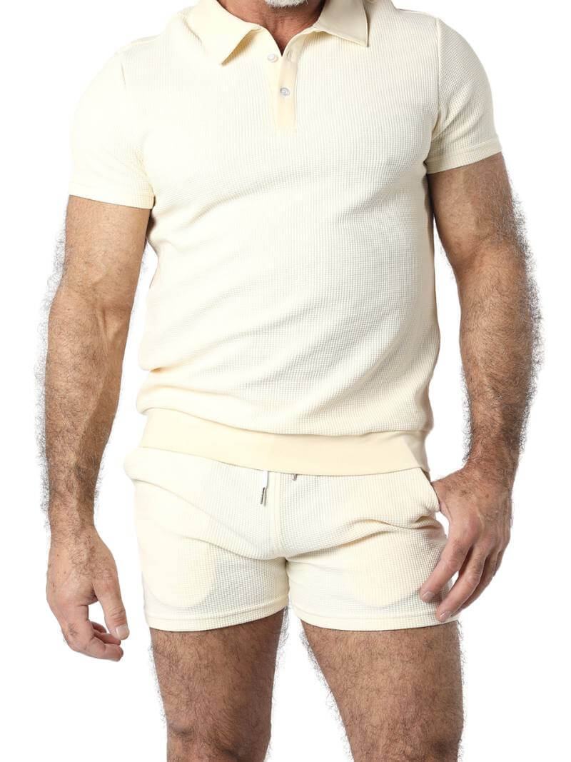 A man wearing mid-thigh length pink knitted shorts with a drawstring waist.