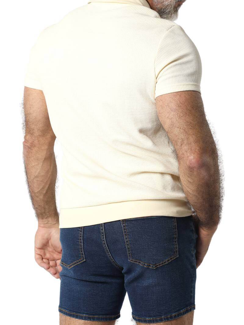 A male model wearing a pink Timoteo Indio polo shirt with short sleeves and a collared neck.