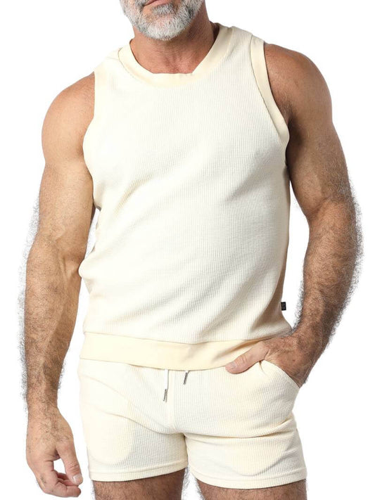 A male model wearing a black sleeveless knitted tank top with a round neck, branded with Timoteo on the side.