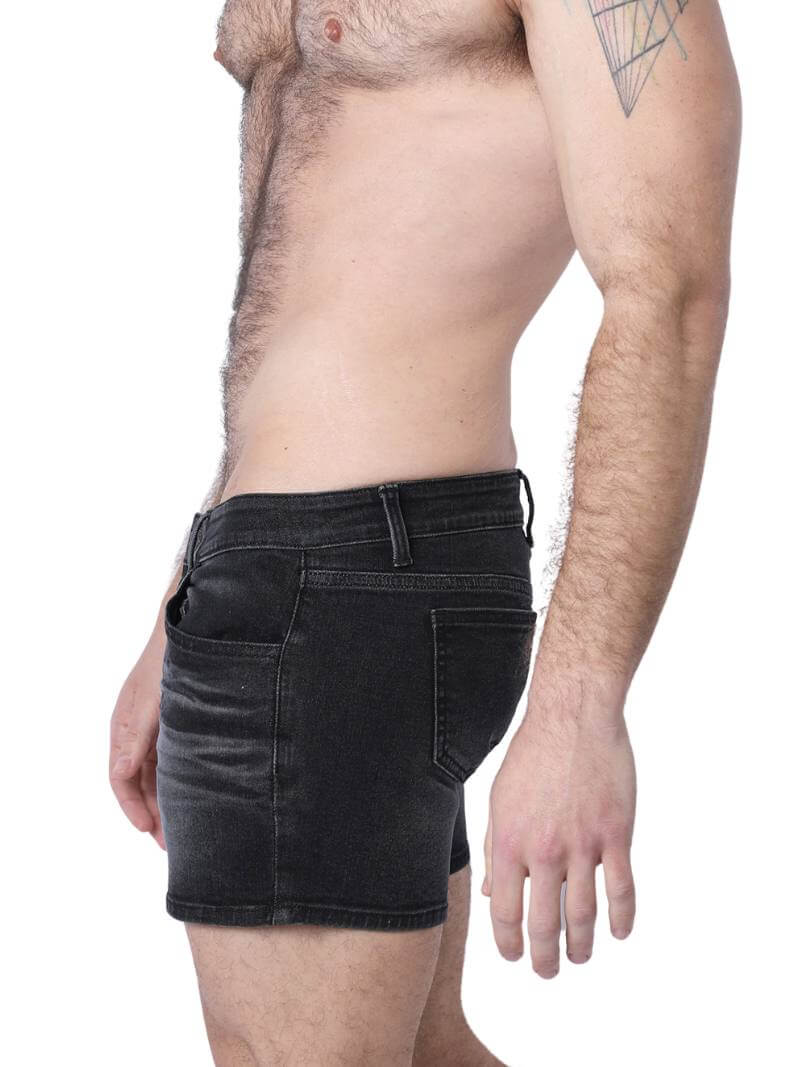 A pair of denim booty shorts with a low-rise waist and a 4-inch inseam, featuring a zipper fly, button fastening, belt loops, and four pockets. The shorts are blue with contrast stitching, and there is a leather branded patch on the back.