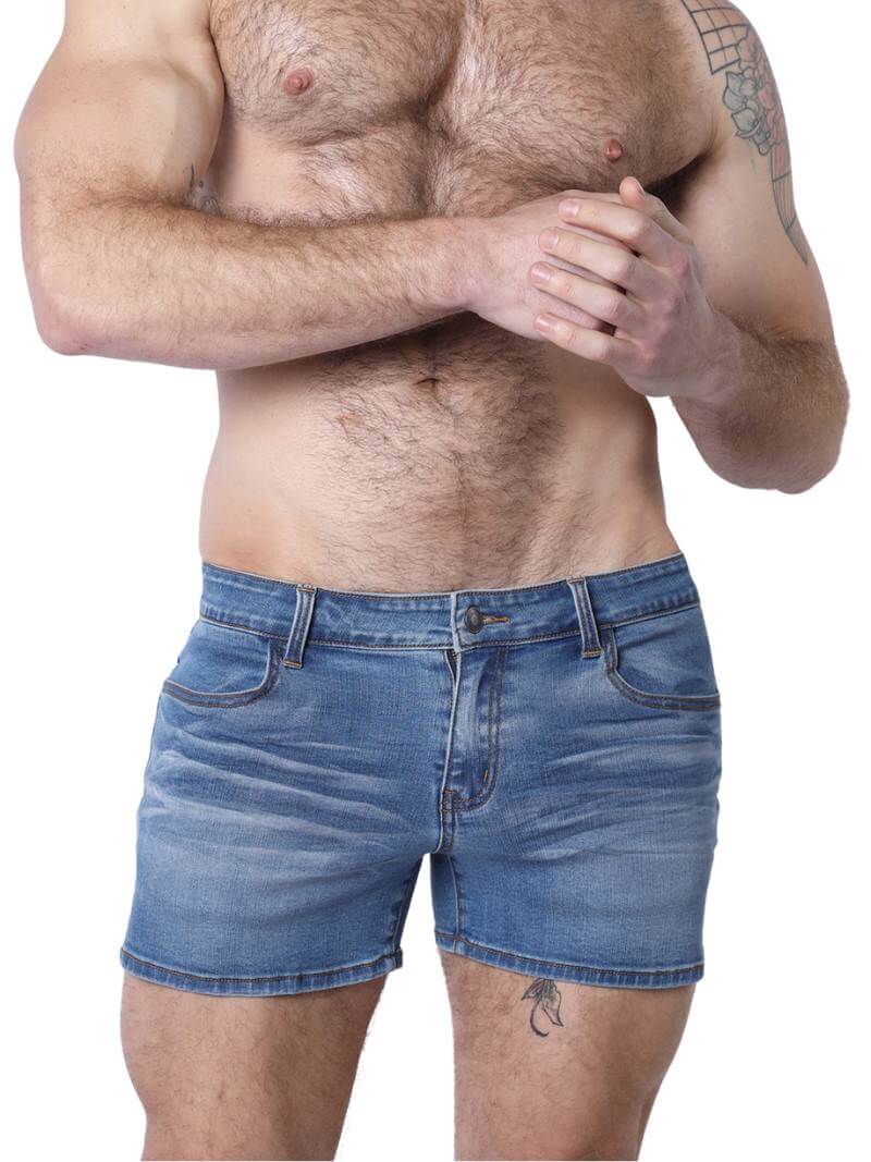 A pair of denim booty shorts with a low-rise waist and a 4-inch inseam, featuring a zipper fly, button fastening, belt loops, and four pockets. The shorts are blue with contrast stitching, and there is a leather branded patch on the back.