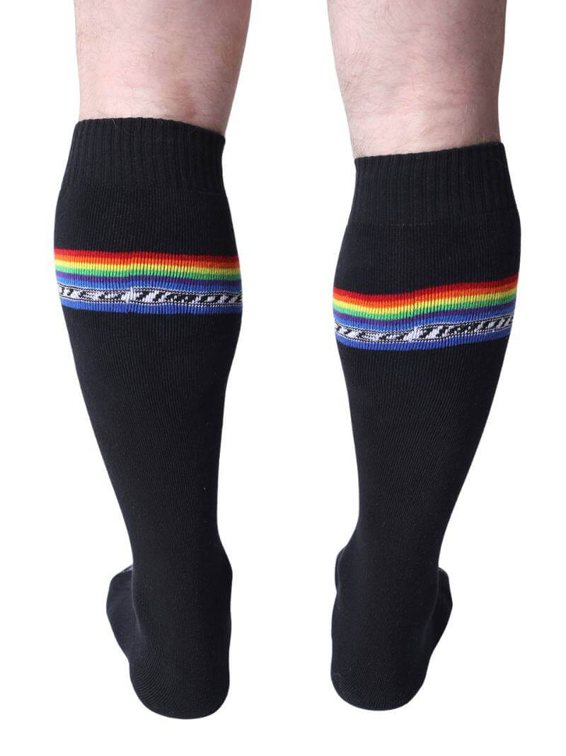 Black socks with rainbow stripes worn by a person on a white background