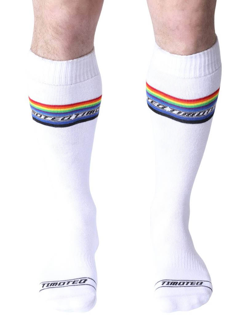 Black socks with rainbow stripes worn by a person on a white background