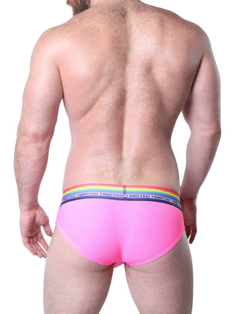 Man wearing pink underwear with rainbow waistband on a white background