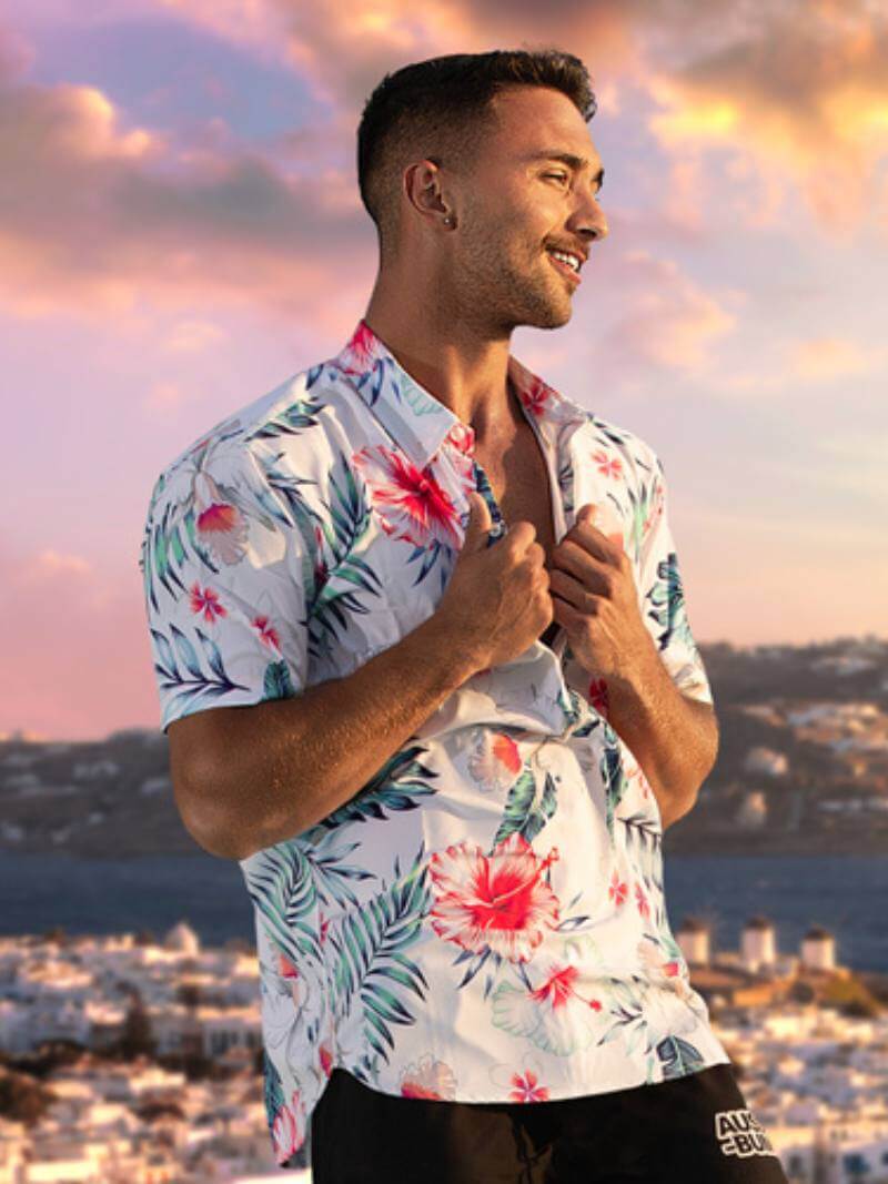 A short-sleeve, collar neck poloshirt with a floral Hawaiian print against a white background.