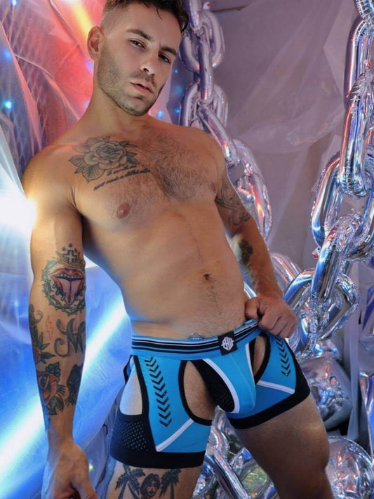 Man wearing blue and black patterned underwear with a colorful, abstract background