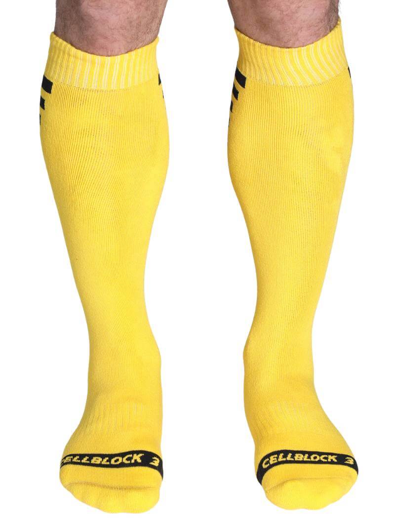 Yellow knee-high socks with black accents on a white background