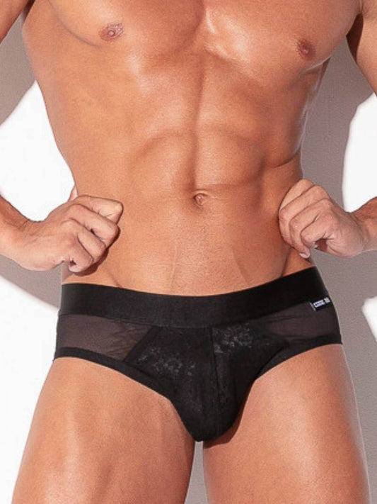 Man wearing a black men's underwear with mesh panels on a neutral background