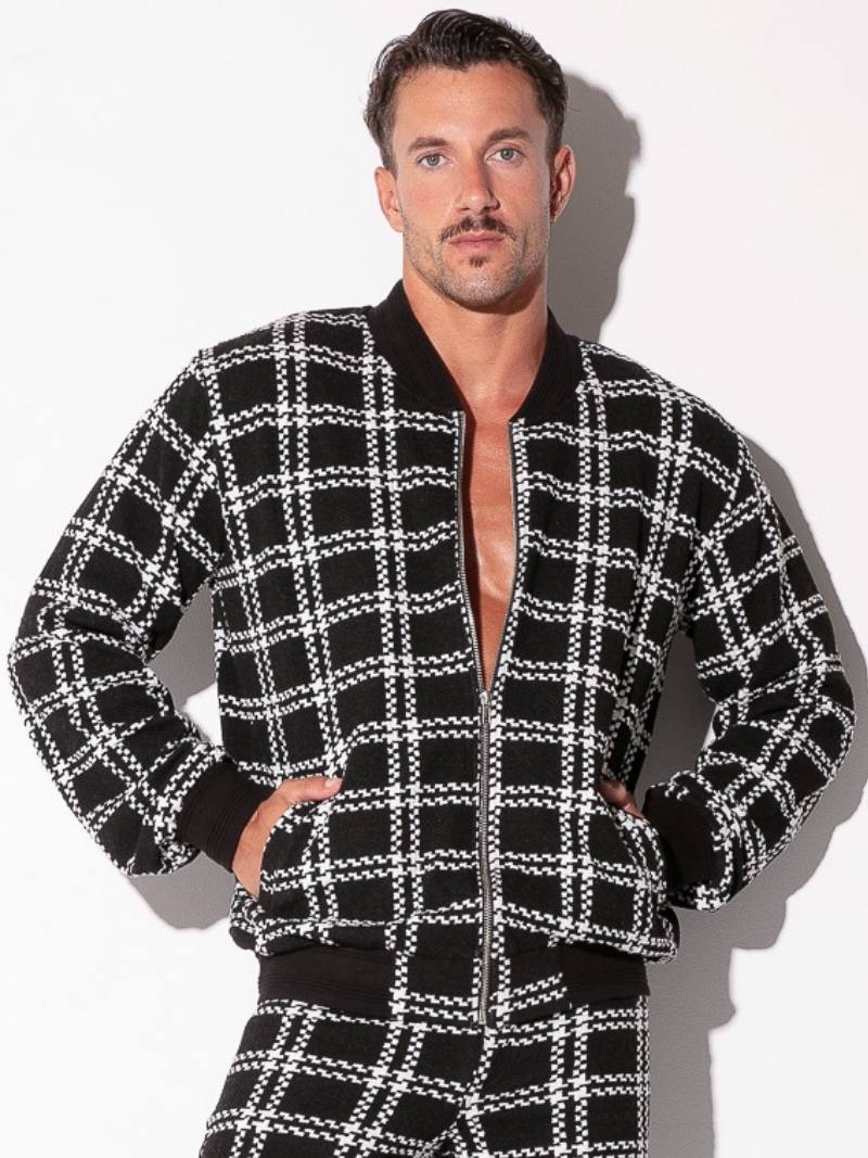 Man wearing a black and white checkered jacket with a plain background
