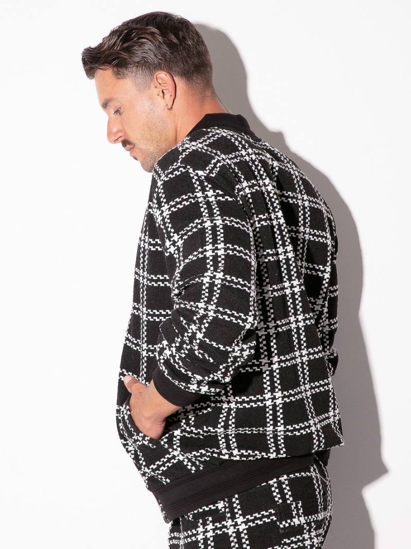 Man wearing a black and white checkered jacket against a white background
