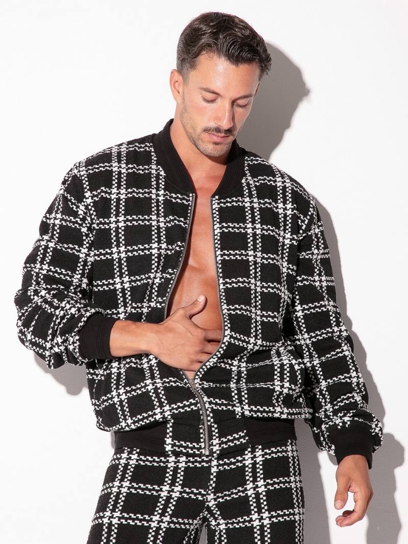 Man wearing a black and white checkered jacket and pants on a white background