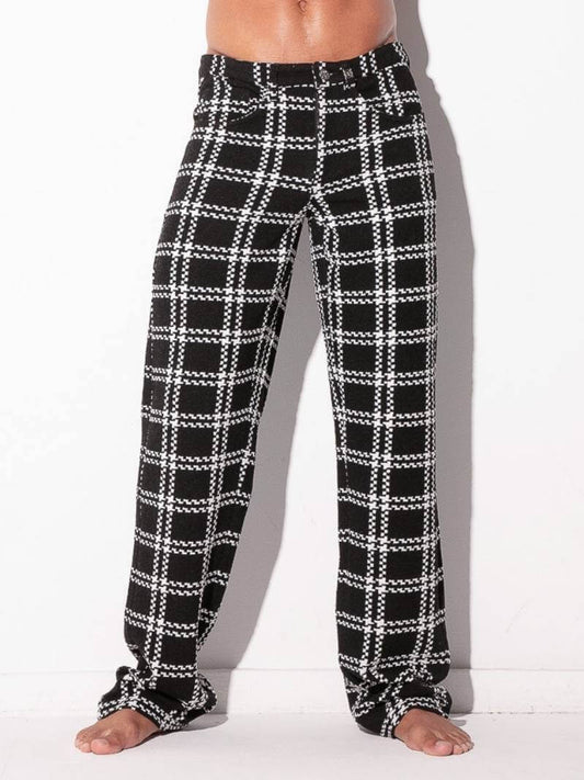 Black and white plaid pajama pants worn by a person on a white background