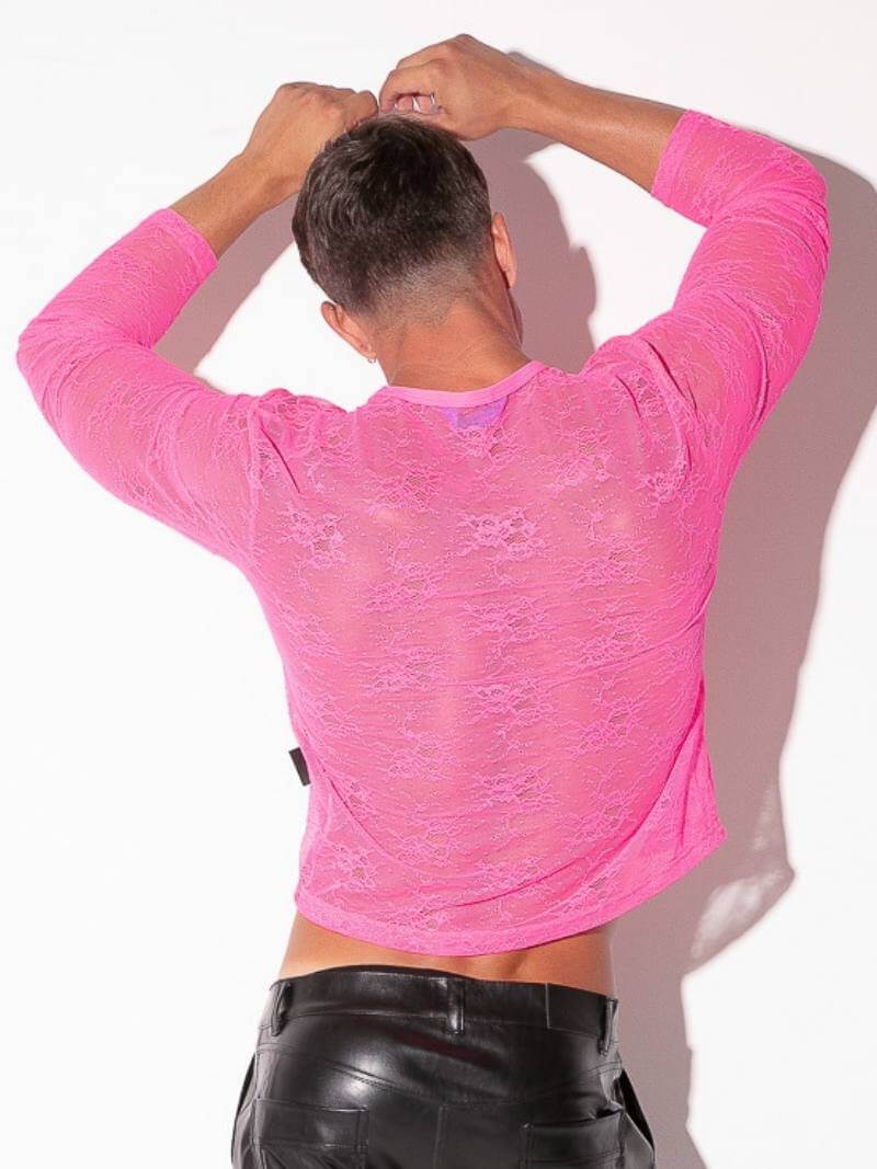 Person wearing a bright pink long-sleeve shirt and black pants against a white background