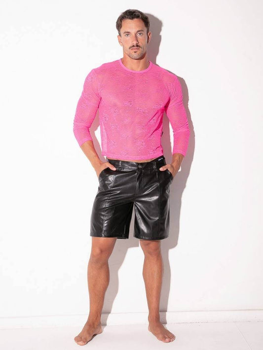 Man wearing a pink long-sleeve shirt and black leather shorts on a white background