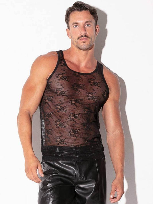 Man wearing a black lace tank top and shiny black pants against a white background