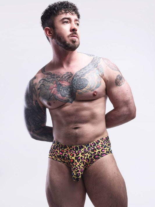 Man wearing leopard print underwear against a plain background