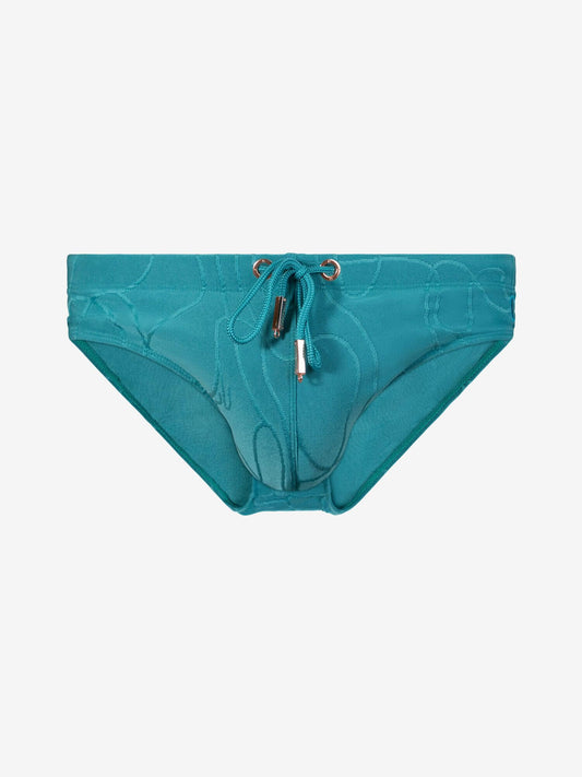 A pair of bikini bottoms featuring a subtle tonal abstract pattern, a front drawstring tie, and a small gold-tone  detail at the center front, displayed against a solid light gray background.