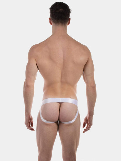 Rear view of a muscular man wearing white men's underwear with a wide waistband and jockstrap leg straps, photographed against a light gray studio background.
