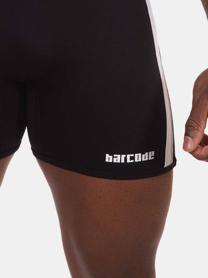 Close-up of a person wearing black athletic shorts with a white side stripe and the word 'barcode' printed in white near the hem, against a light gray background.