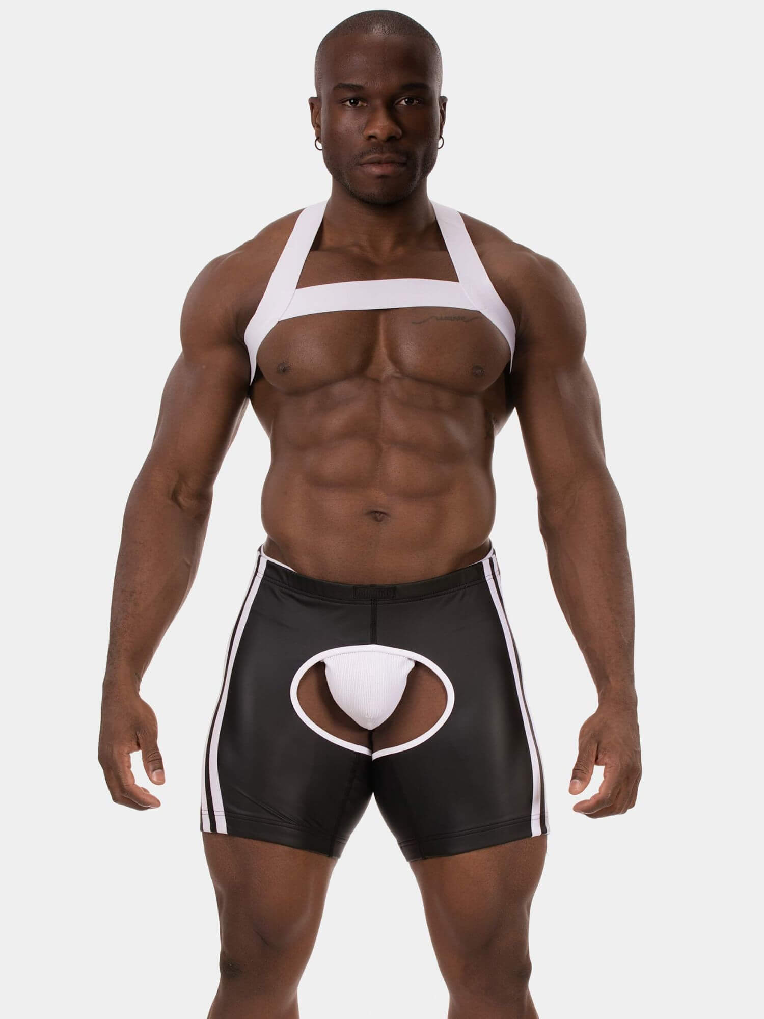 A muscular male model wearing black and white men's briefs with a white pouch insert and white side stripes, against a light gray studio background.