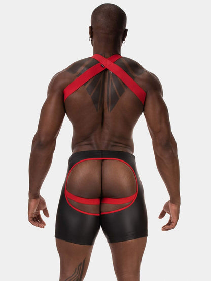 Rear view of a muscular man wearing black men's briefs with red elastic straps and a large rear cutout, set against a solid light gray background.