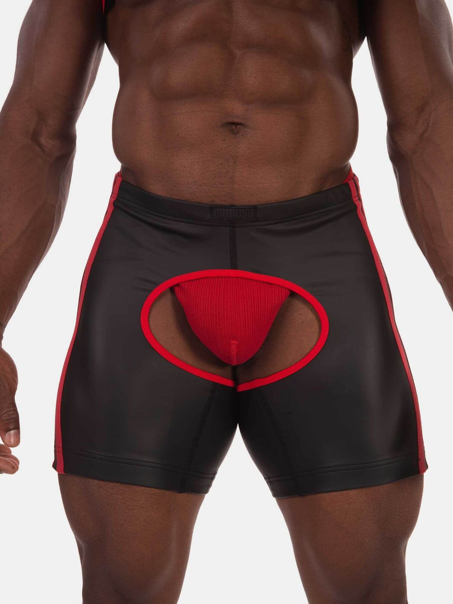 Black men's athletic briefs with red side stripes and a red front pouch, shown on a male model against a light gray background.