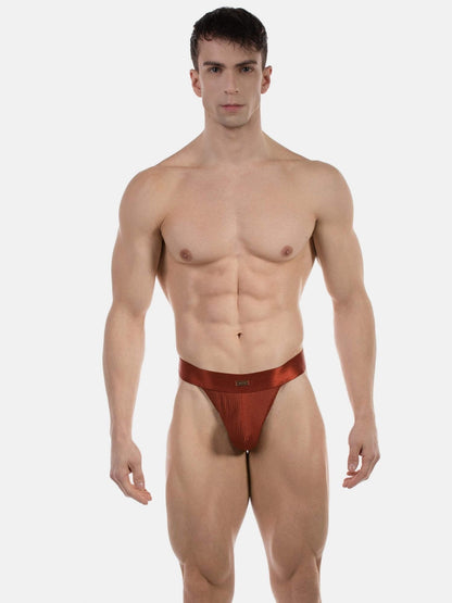 Man wearing a red thong against a white background