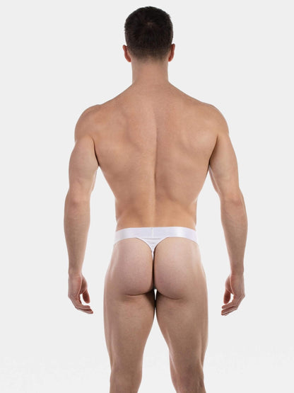 Rear view of a muscular man wearing a white thong against a light gray studio background.
