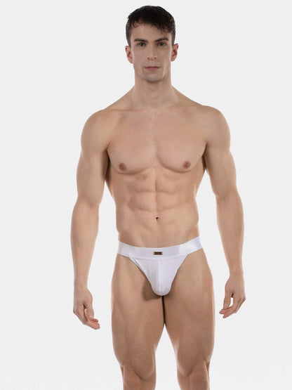 A muscular male model wearing a white low-rise brief, standing against a solid light gray background.