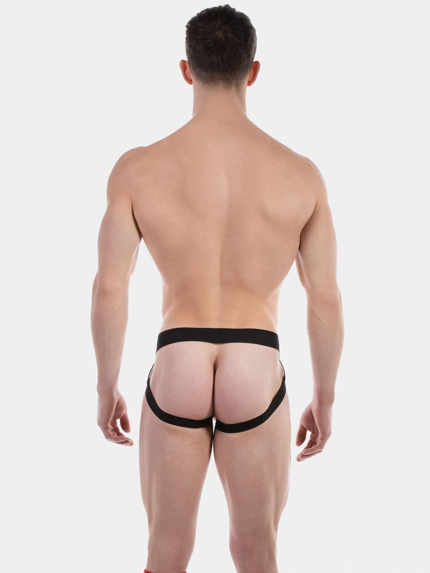Man wearing a black jockstrap on a white background
