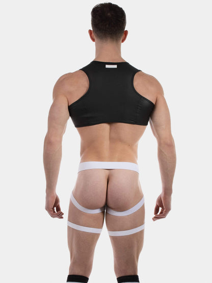 Rear view of a muscular man wearing a black athletic crop top and white thigh straps against a light gray studio background.