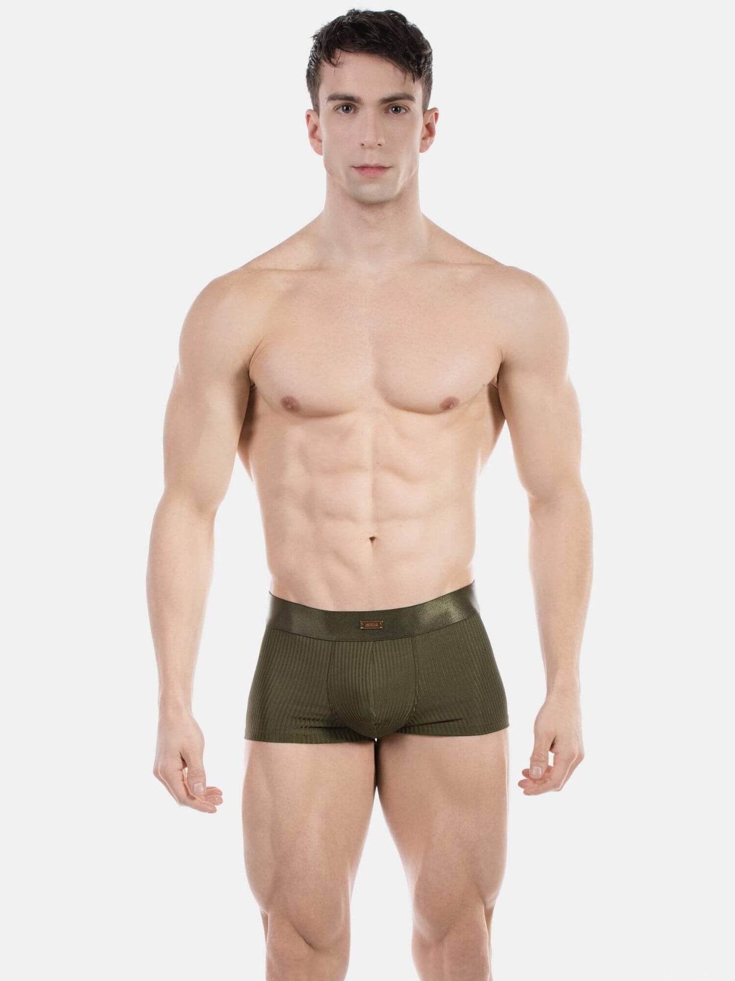 A muscular man modeling a pair of olive green ribbed boxer briefs against a plain light gray studio background.