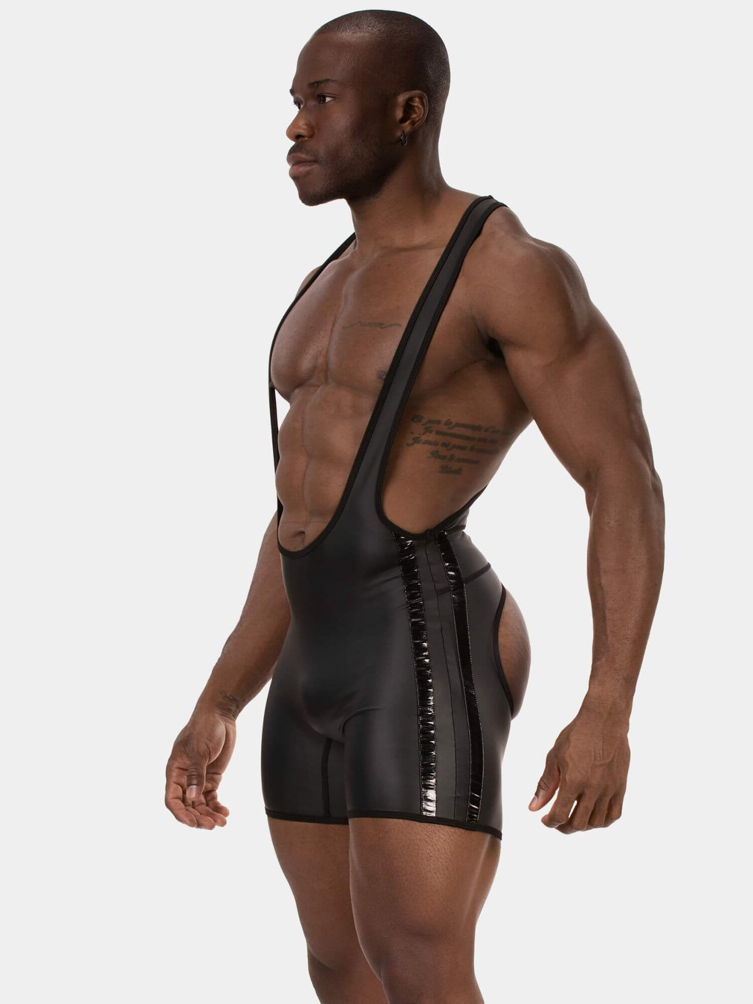 A muscular male model wearing a black wrestling singlet with black trim, against a solid light gray background.