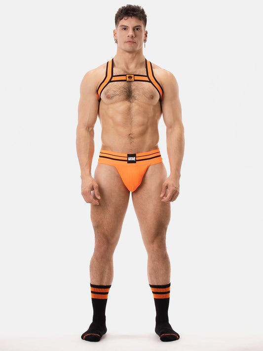 Man wearing Barcode Berlin neon orange harness and underwear set on a white background