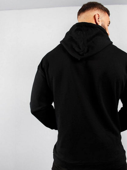Person wearing a black hoodie from behind on a light gray background