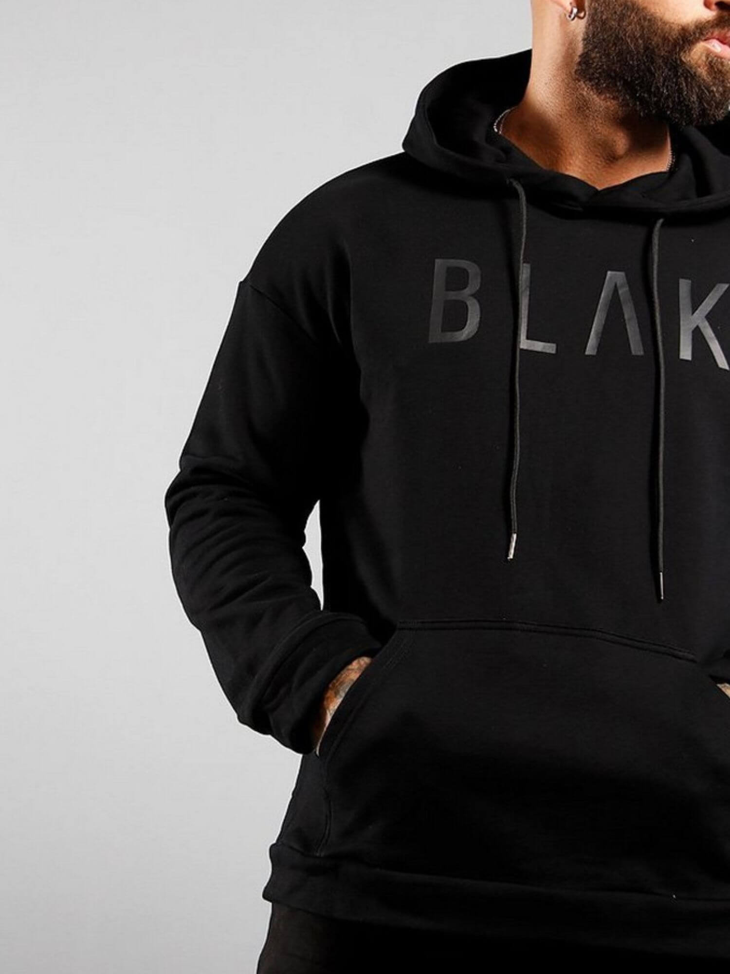 Person wearing a black hoodie with 'BLAK' branding on a gray background