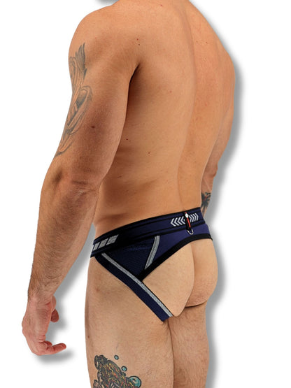 Man wearing a black and blue men's underwear with visible tattoos on a white background