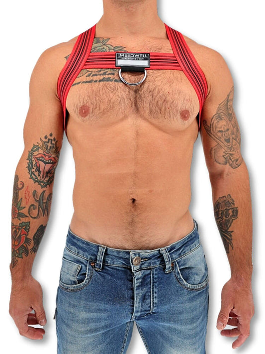 Person wearing a red harness with tattoos on arms and chest, on a white background