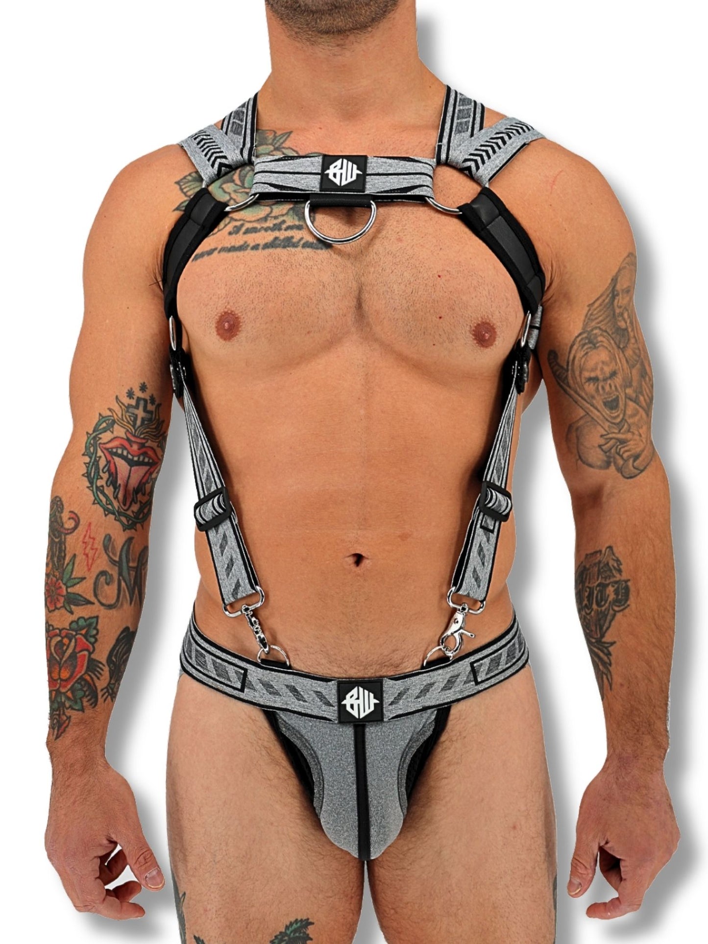 Man wearing a harness with visible tattoos on a white background