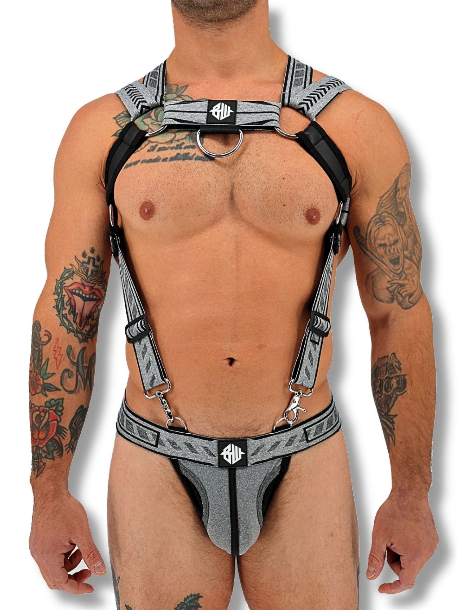 Man wearing a harness with visible tattoos on a white background