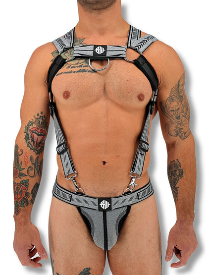 Man wearing a harness with visible tattoos on a white background