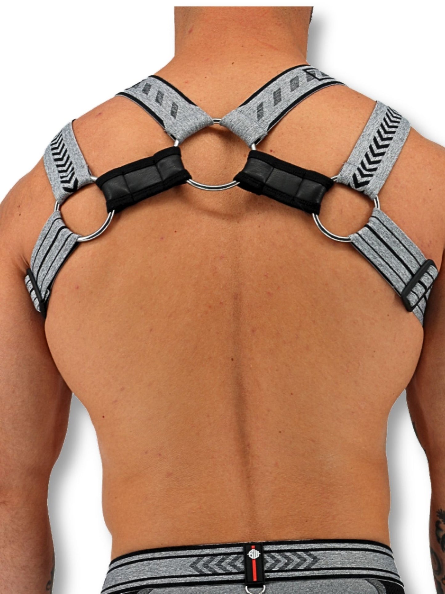 Person wearing a gray and black harness on a white background