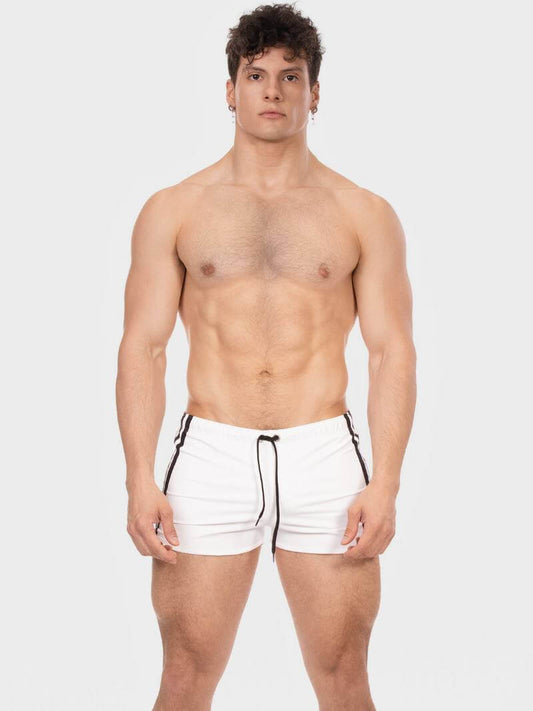 Man wearing white swim shorts with black drawstring on a light gray background