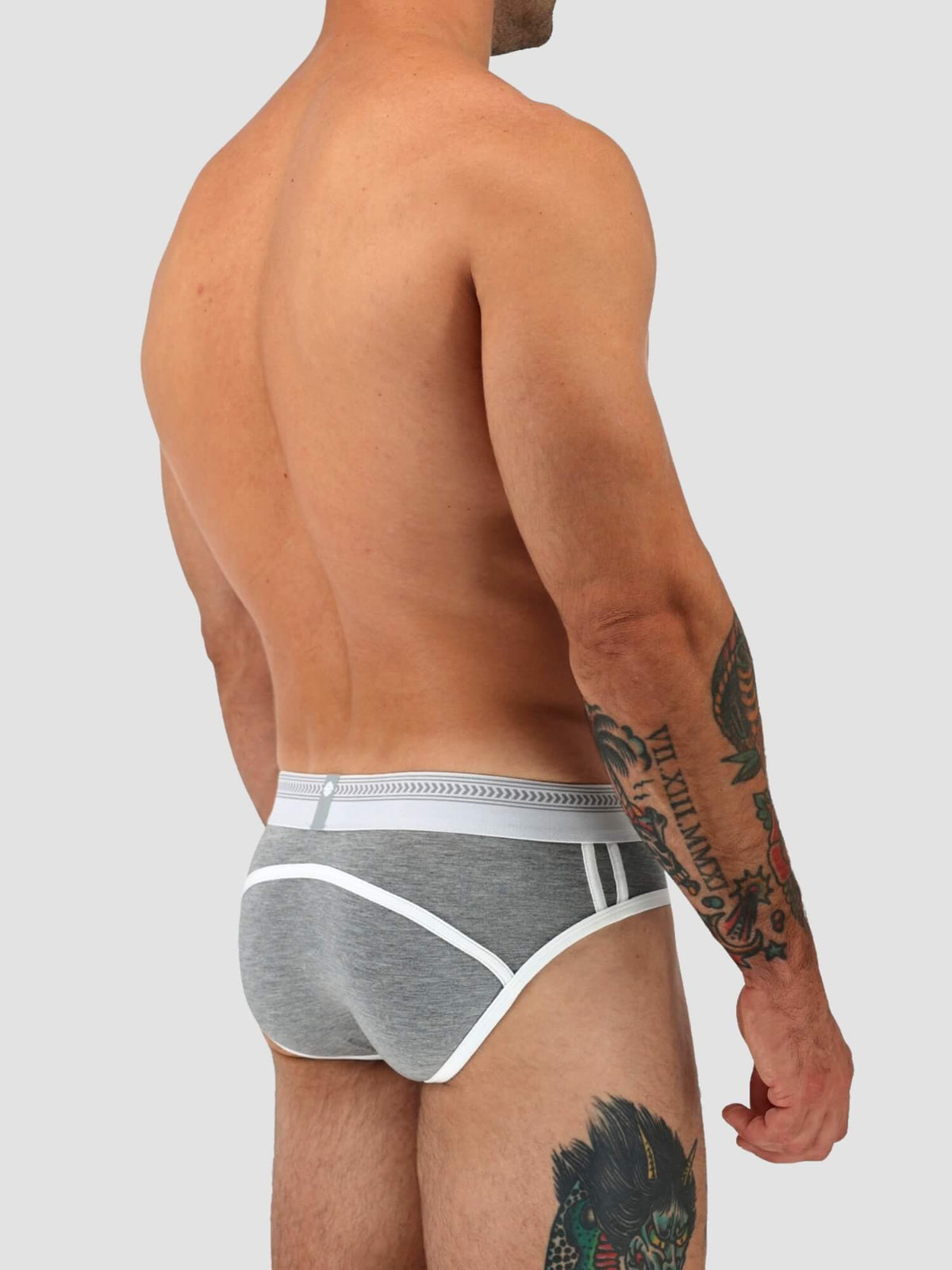 A man shown from the back wearing gray heathered briefs with white trim and a white waistband, against a light gray studio background.