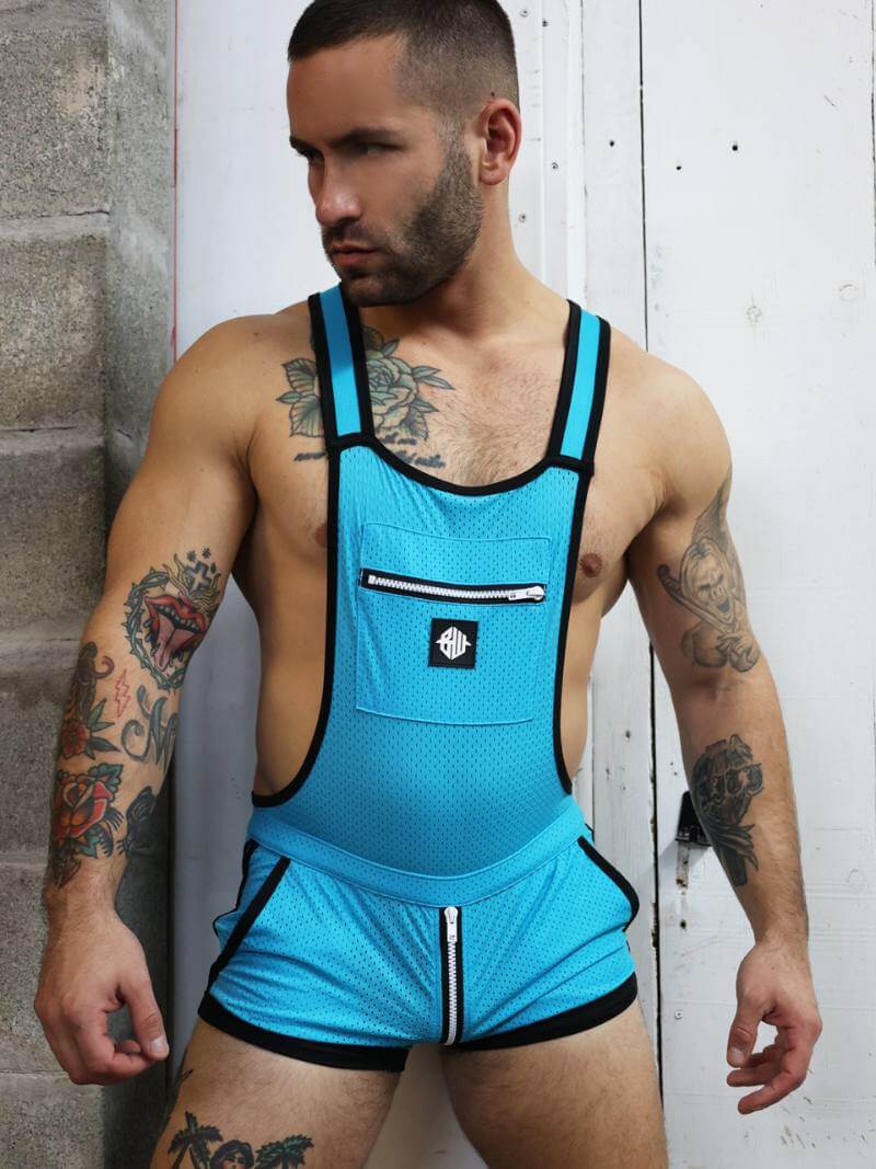 Man wearing a blue athletic outfit with tattoos on his arms and chest.