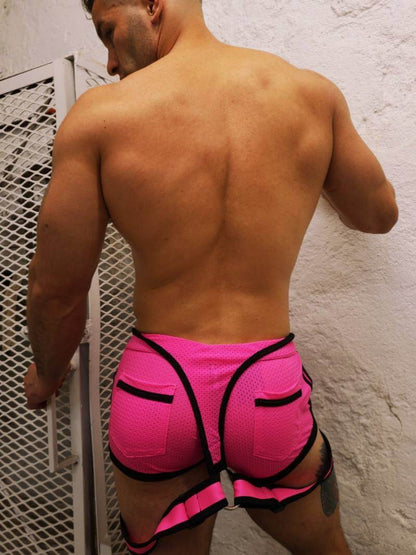 Man wearing a Breedwell Sluterall neon pink and black outfit with neon lights in the background
