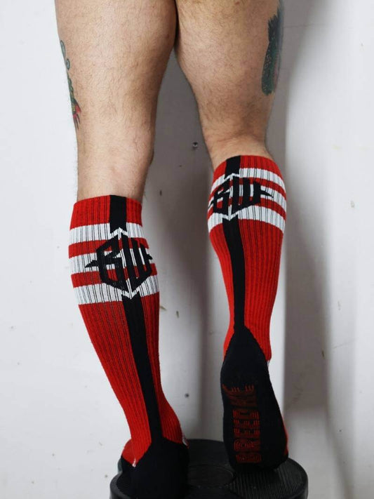 Red and black socks with a logo worn by a person on a white background