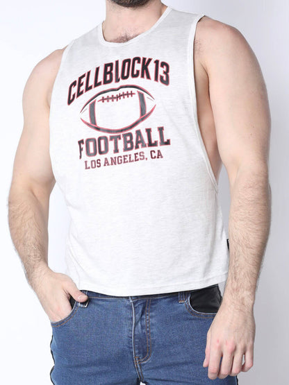 A man wearing a white sleeveless tank top with a dark red graphic that reads 'CELLBLOCK13 FOOTBALL LOS ANGELES, CA' and an illustration of a football, paired with blue jeans.