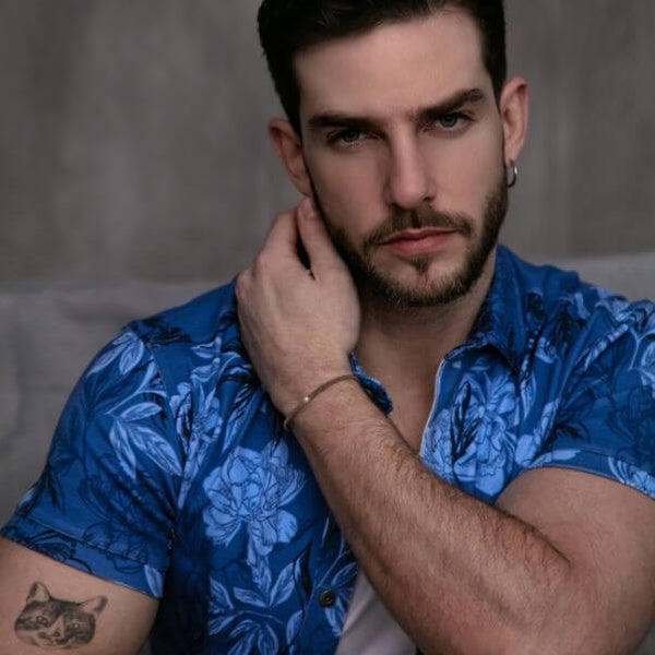 Man wearing a blue floral shirt against a neutral background