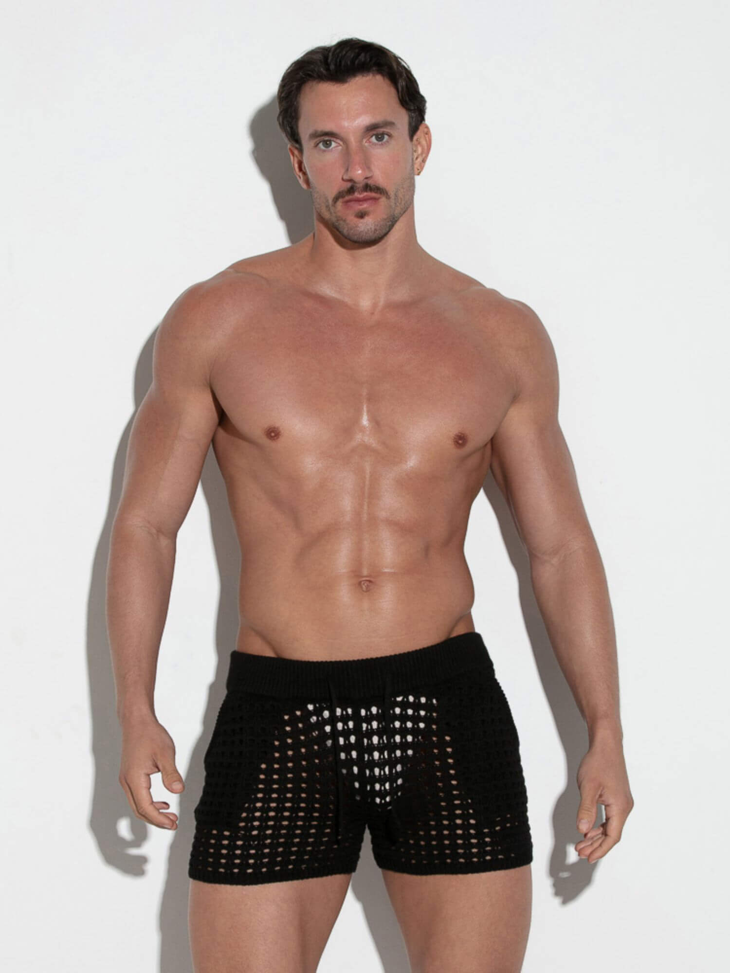 Man wearing black shorts against a white background